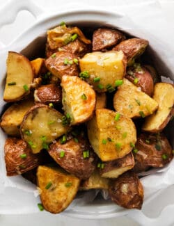 Overhead view of a bowl of garlic roasted new potatoes