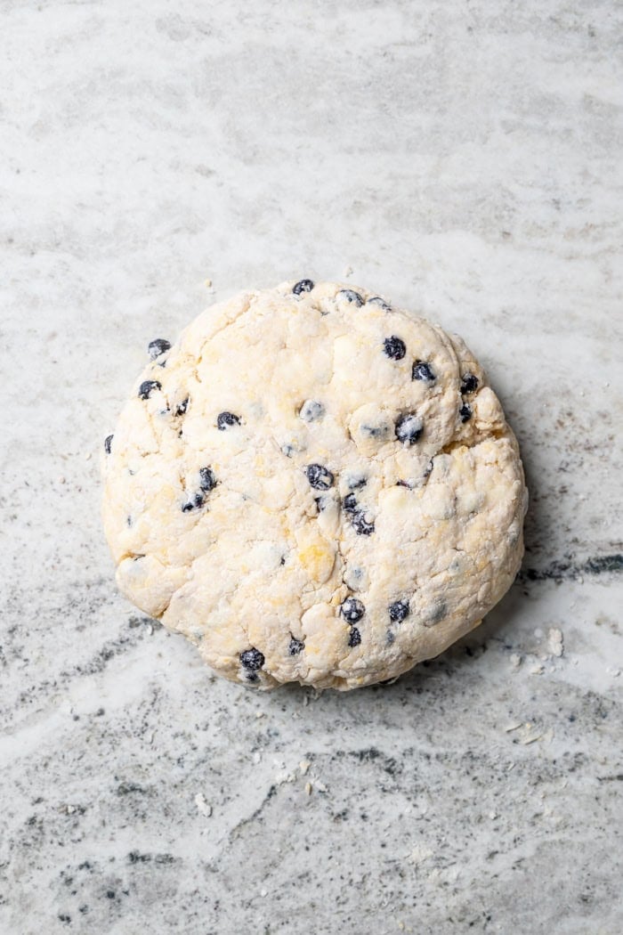 Rich, flaky and dotted with chewy dried blueberries, these blueberry scones are a bakery-style treat you can easily make at home! Overhead view of dough for blueberry scones