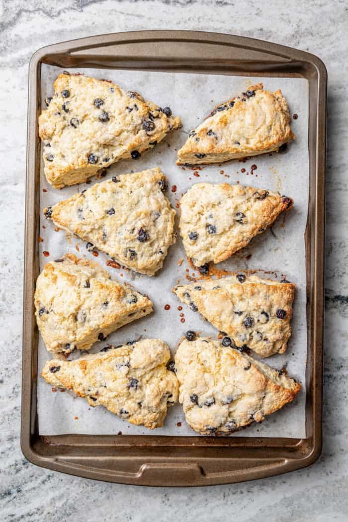 Overhead view of blueberry scones on parchment-lined baking sheet