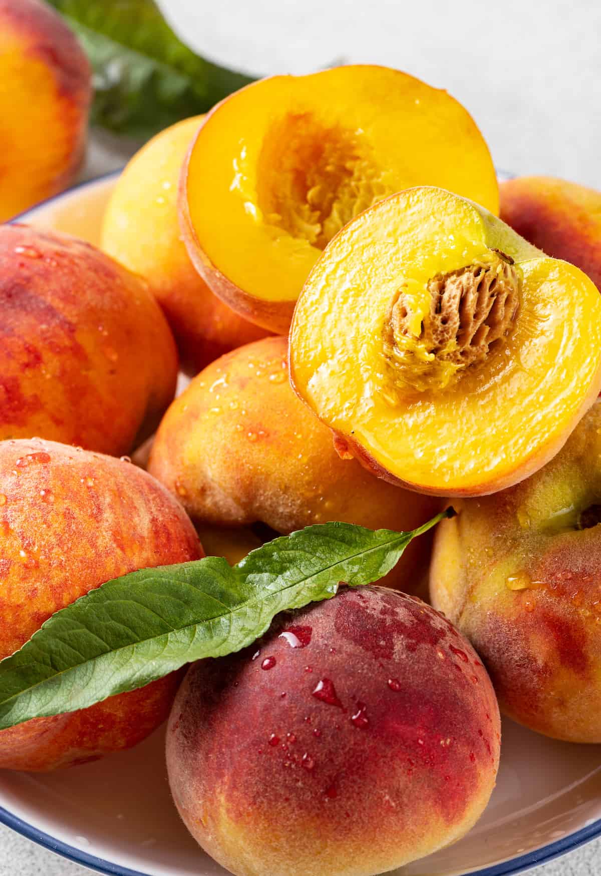 Made with just 10 ingredients, this Homemade Peach Pie is perfectly spiced and topped with a beautiful golden brown flaky lattice crust. A bowl of peaches, some cut in half