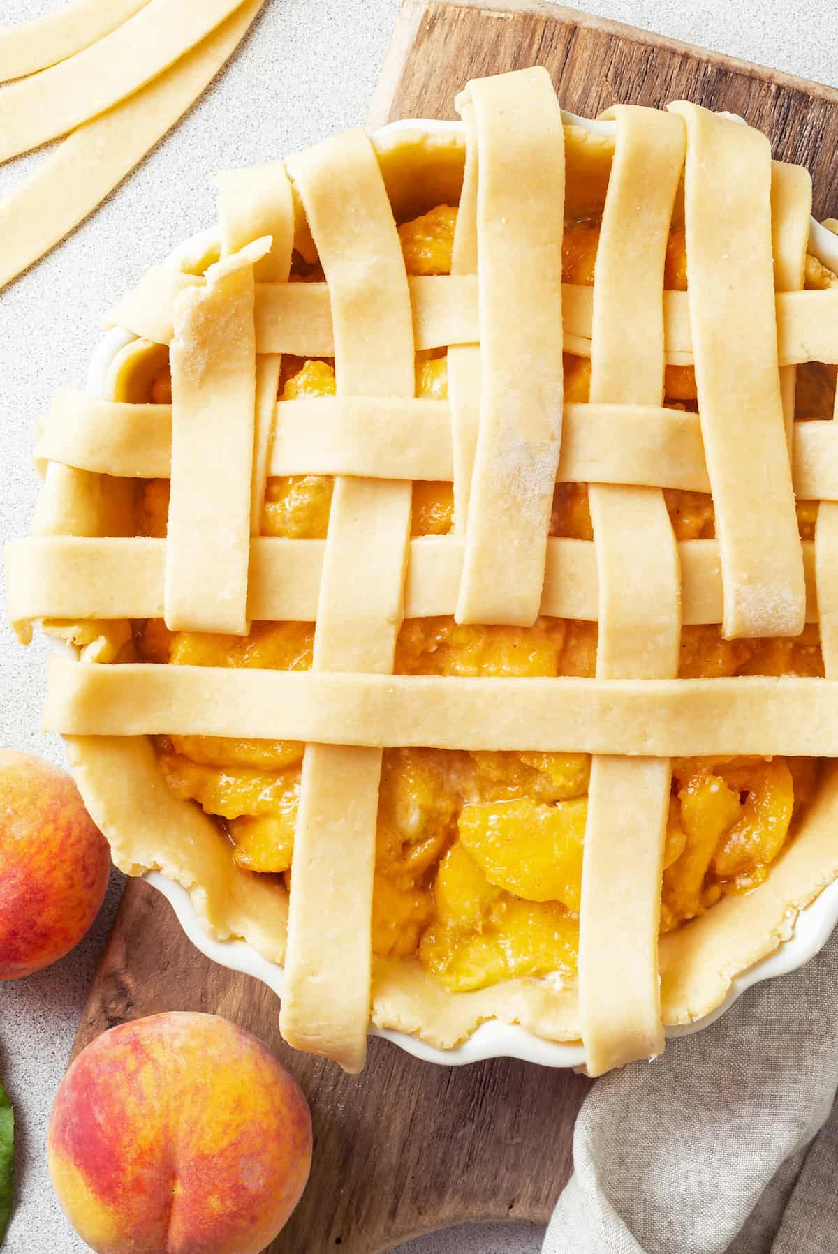 Made with just 10 ingredients, this Homemade Peach Pie is perfectly spiced and topped with a beautiful golden brown flaky lattice crust. A homemade peach pie with a half-finished lattice crust