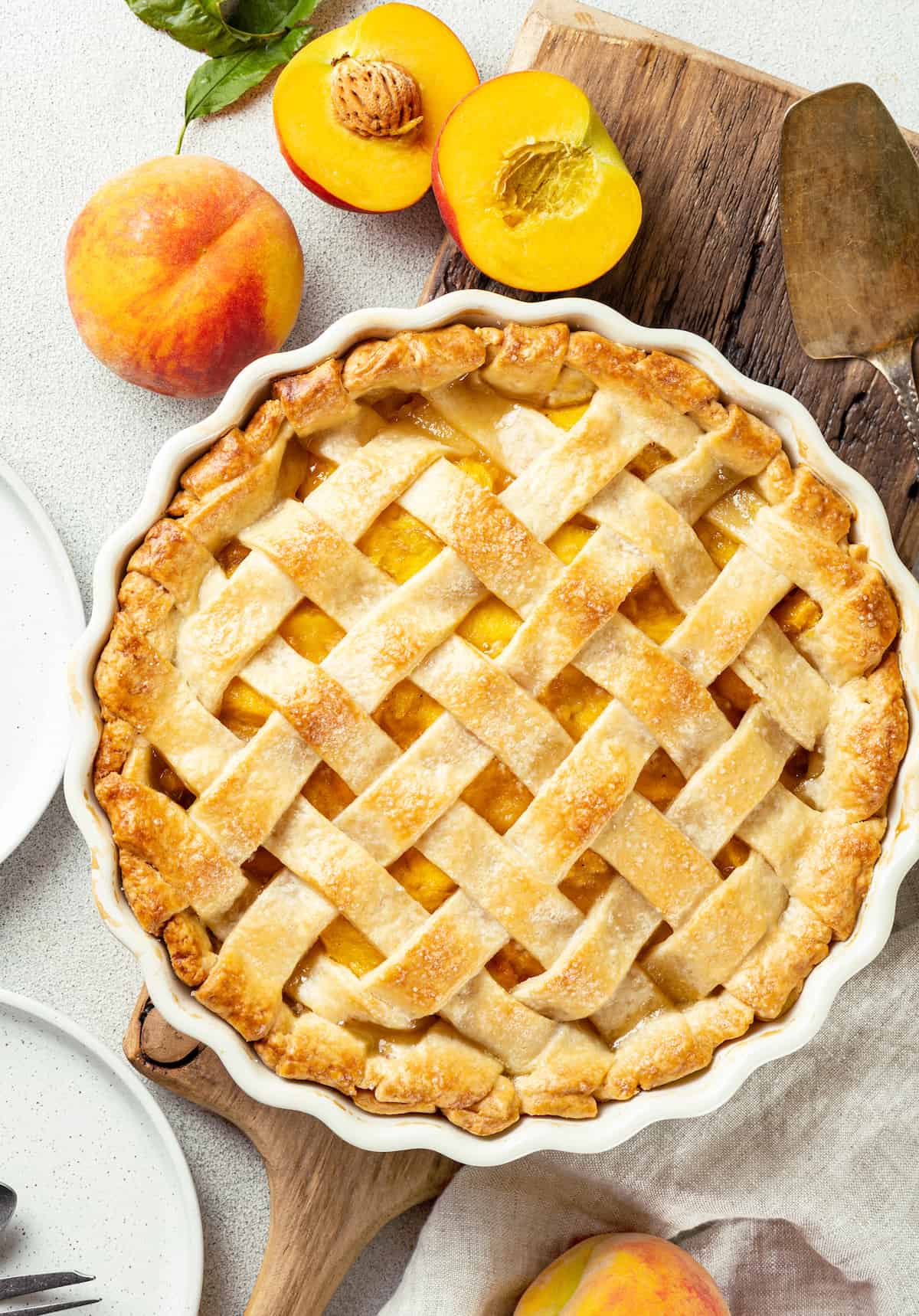 Made with just 10 ingredients, this Homemade Peach Pie is perfectly spiced and topped with a beautiful golden brown flaky lattice crust. Overhead view of a homemade peach pie