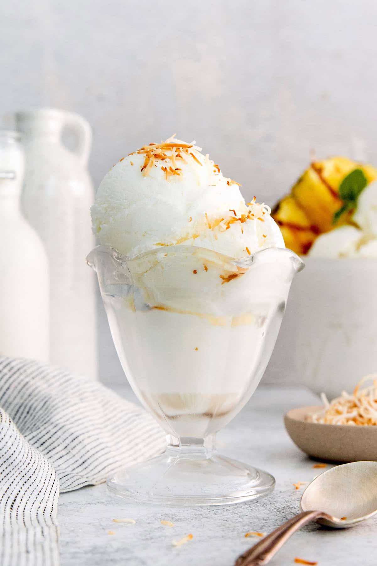 Ultra creamy homemade Coconut Ice Cream is pure summertime fun! You only need 3 simple ingredients to whip up this easy recipe. Coconut ice cream in glass dish with toasted coconut on top