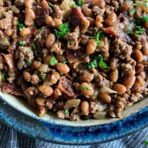 a bowl of baked beans with bacon and ground beef