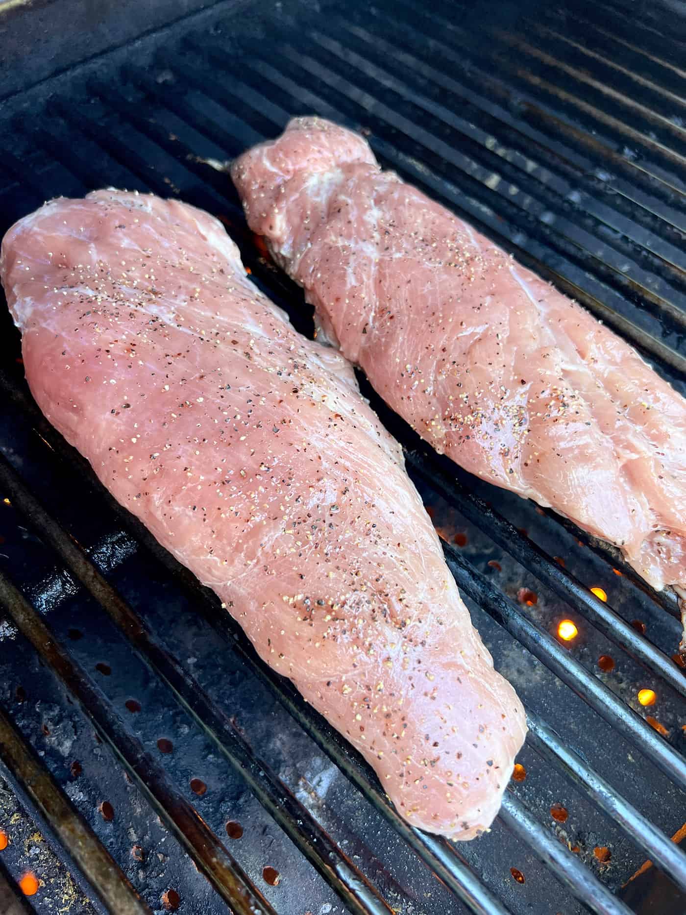 Tender, juicy Grilled Pork Tenderloin is glazed with a sweet peach sauce then topped with an orange-habanero mojo. Two pork tenderloins on the grill