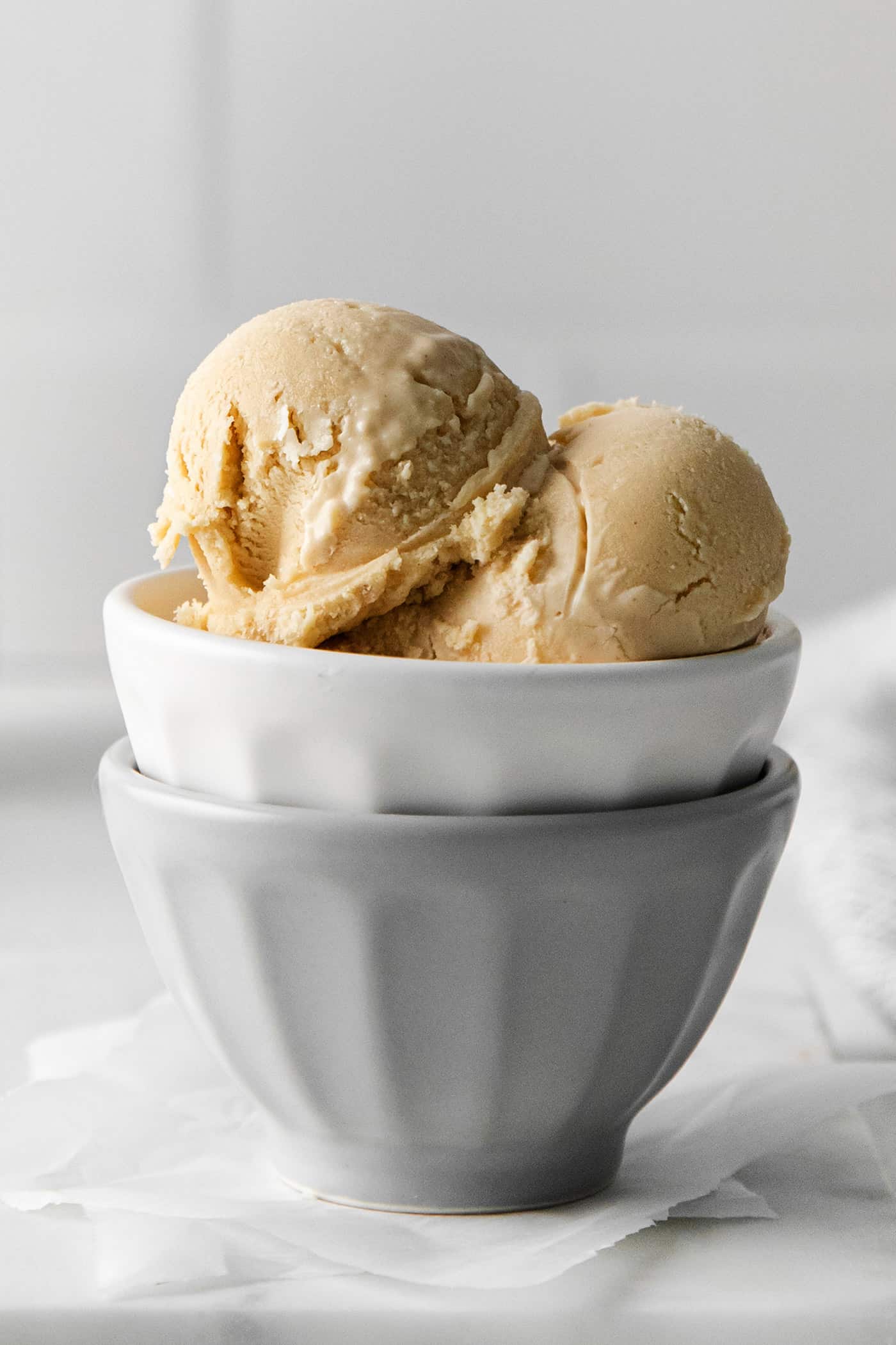 Made with just 5 ingredients and an ice cream maker, this Homemade Peanut Butter Ice Cream is sweet, creamy, and easy to make. Close-up of scoops of peanut butter ice cream in a bowl