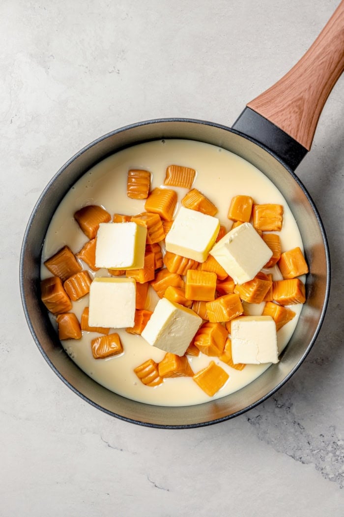 This Caramel Apple Dip beats the pants off of any store-bought caramel dips. Guaranteed! It’s also super easy to make with 3 ingredients. Overhead view of butter, caramels, and condensed milk in saucepan