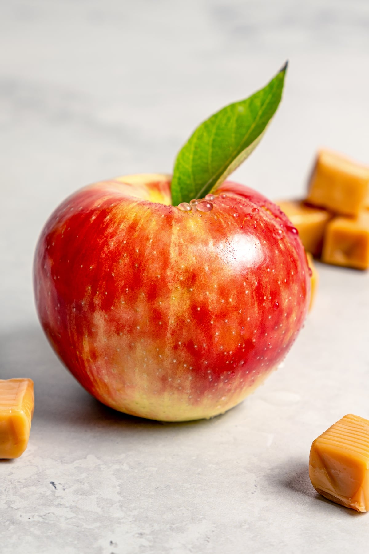 This Caramel Apple Dip beats the pants off of any store-bought caramel dips. Guaranteed! It’s also super easy to make with 3 ingredients. Apple with droplets of water and leaf