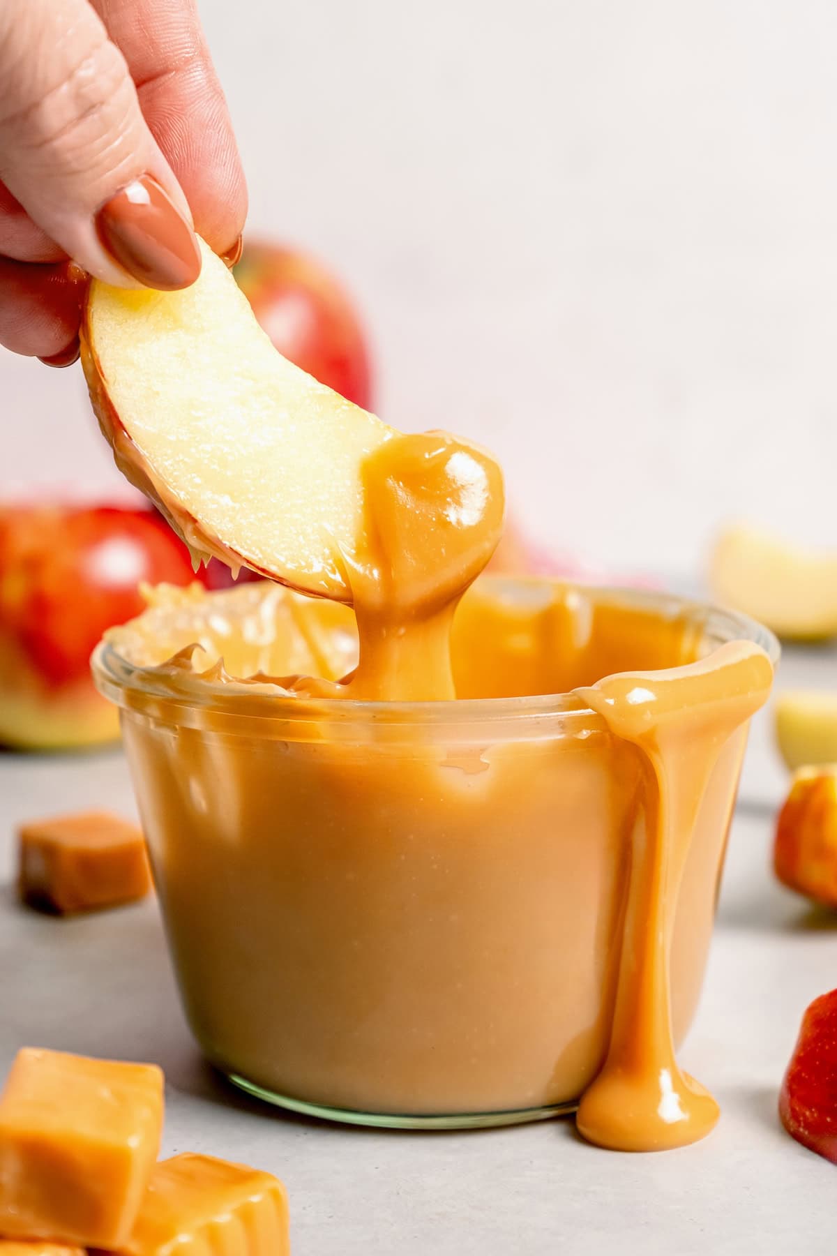 This Caramel Apple Dip beats the pants off of any store-bought caramel dips. Guaranteed! It’s also super easy to make with 3 ingredients. Dipping apple into jar of caramel apple dip
