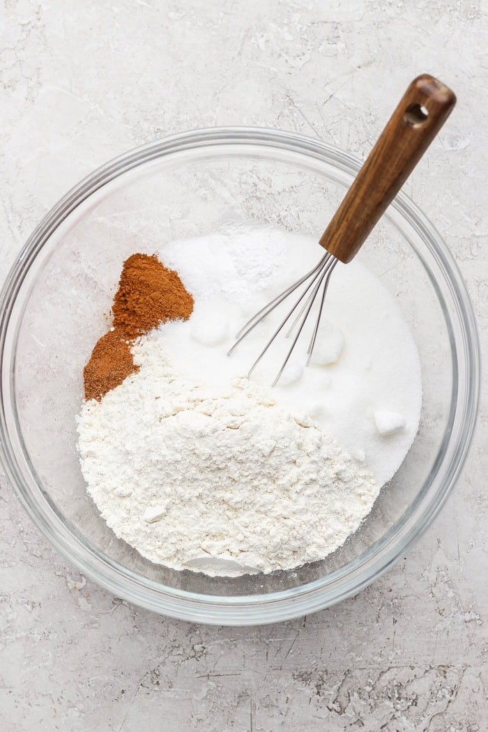 Overhead view of dry ingredients for doughnut muffins in bowl with whisk