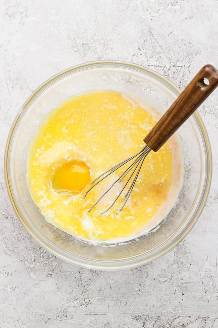 Overhead view of wet ingredients for doughnut muffins in bowl with whisk