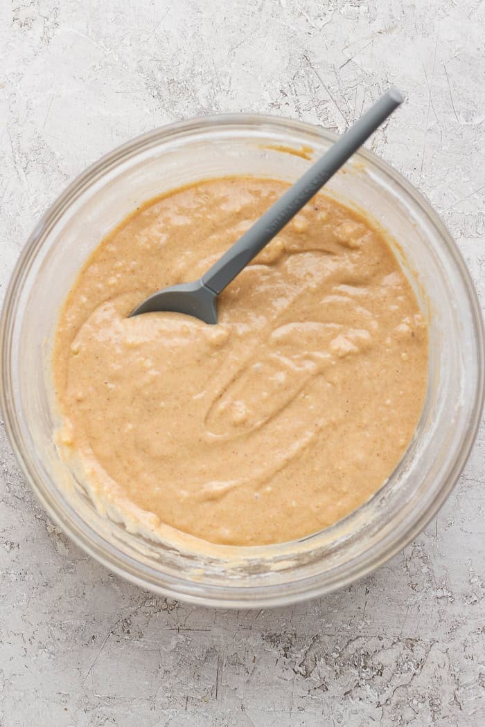 Overhead view of batter for cinnamon sugar doughnut muffins in bowl with spoon