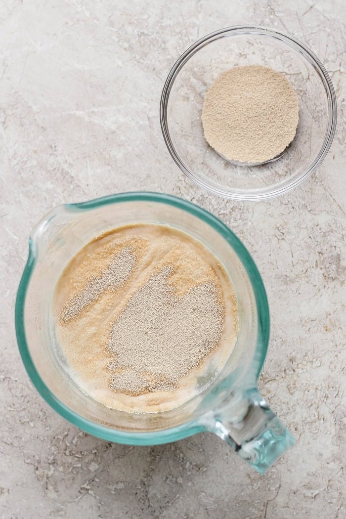 Yeast added to warm water in liquid measuring cup.
