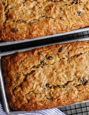 two loaves of apple bread in pans on cooling rack