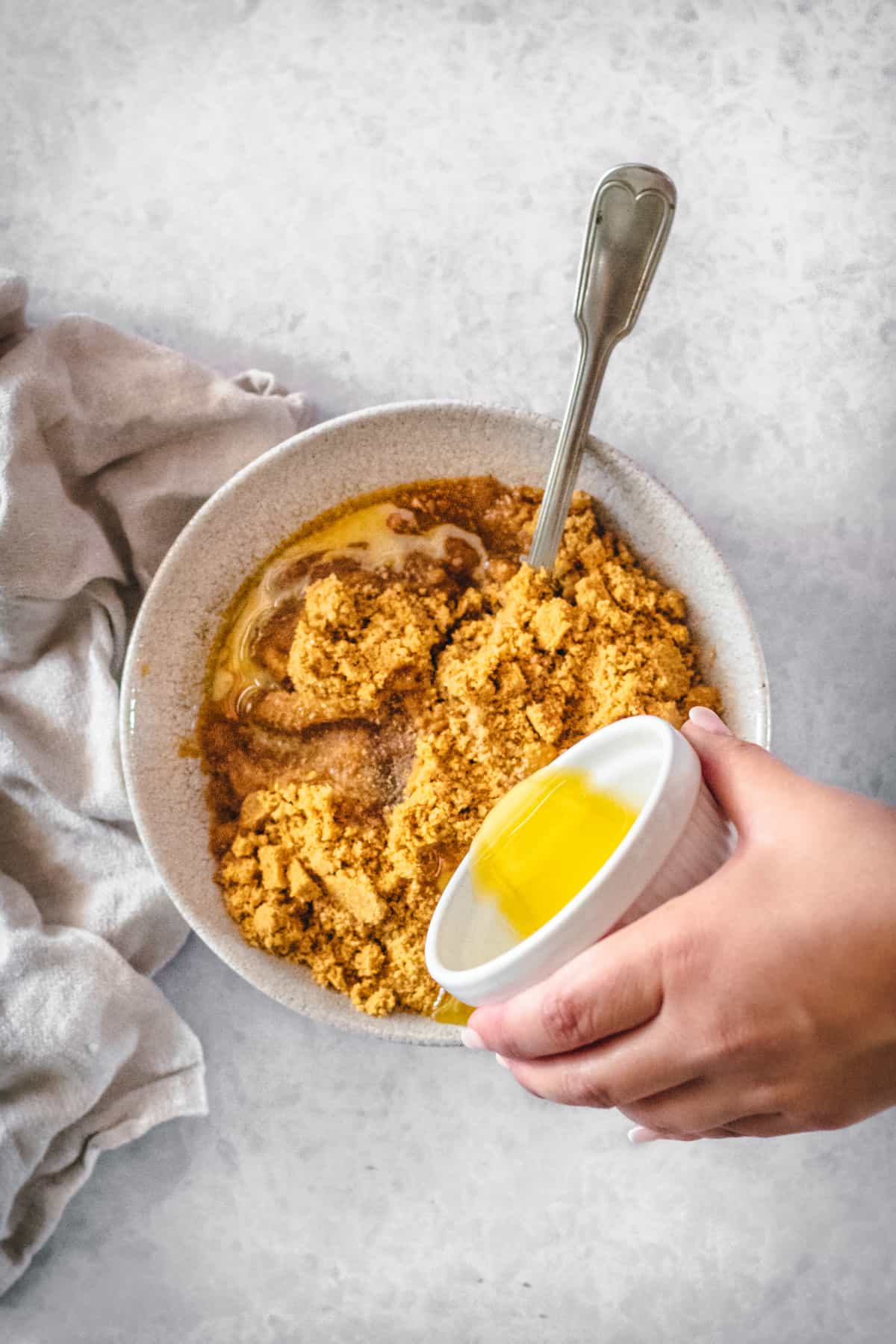 This is the best pumpkin cheesecake recipe! It's creamy, easy to make, and packed with pumpkin flavor, baked in a crunchy gingersnap crust. Butter being added to gingersnap crumbs