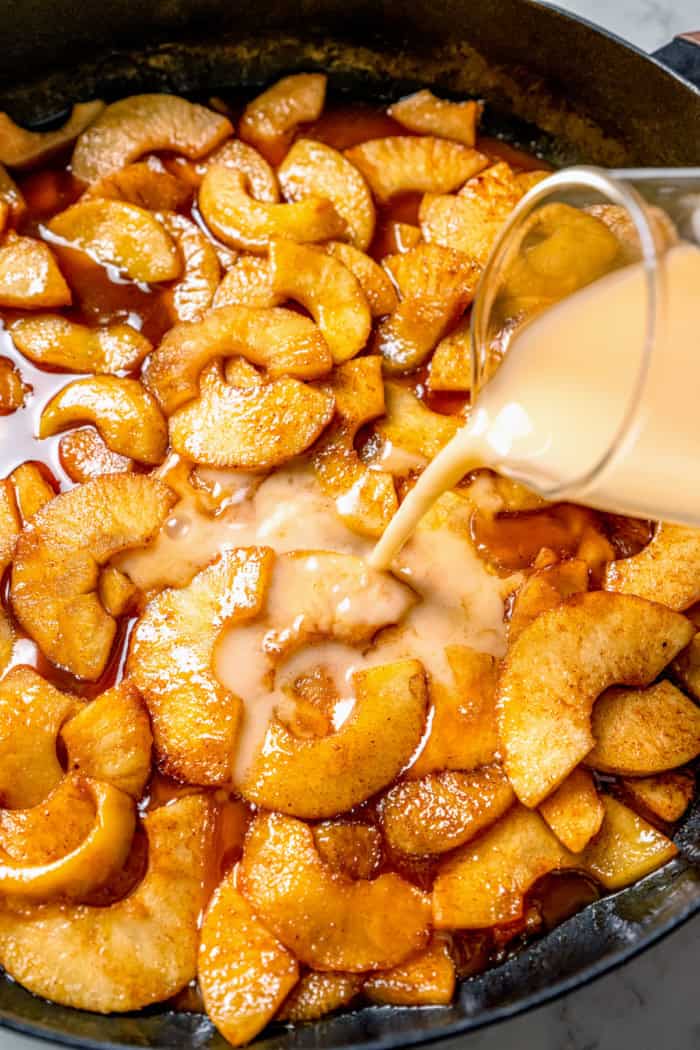 Pouring cornstarch slurry into pan of sautéed apples