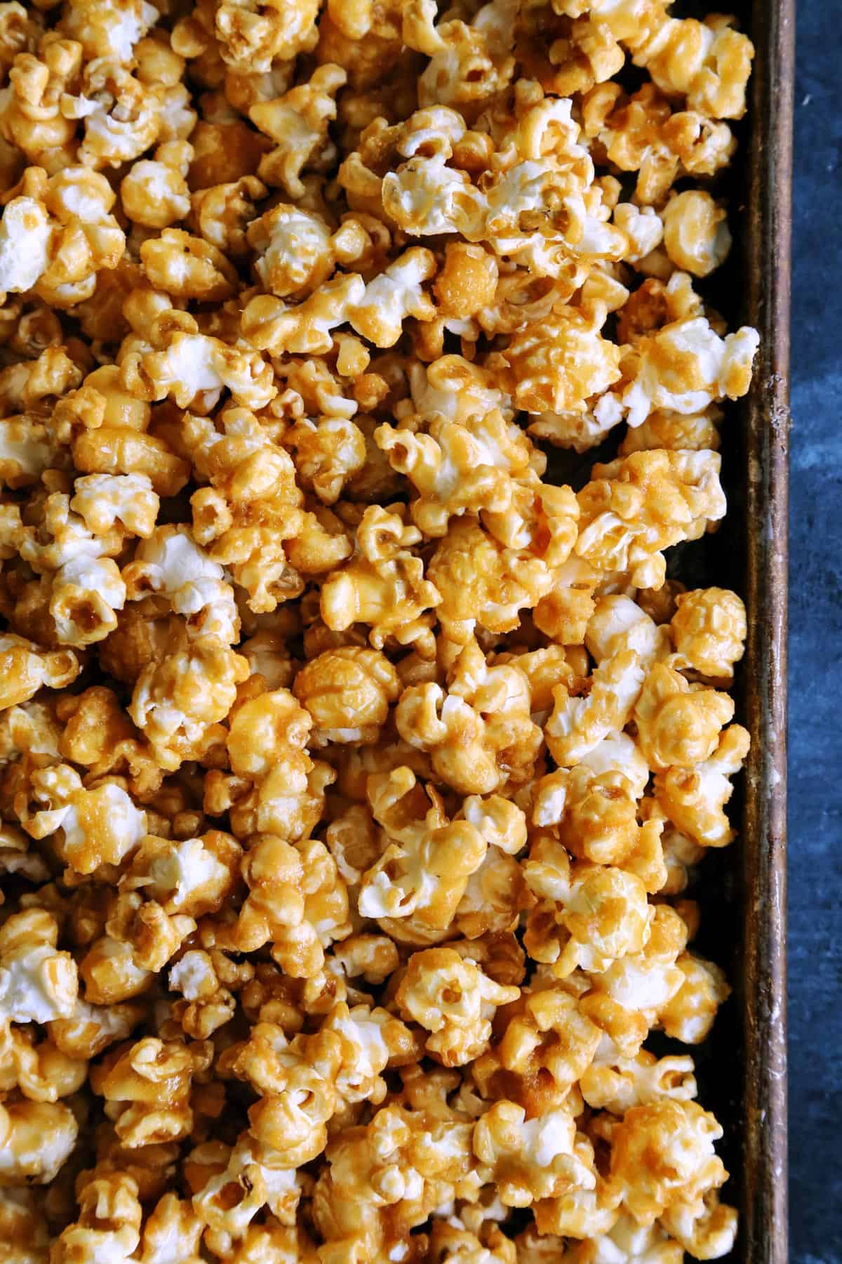 This baked caramel corn is the BEST homemade caramel popcorn recipe! It's crispy, sweet, buttery perfection. Great for gifting and snacking! a pan of caramel covered popcorn