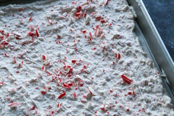 Creamy, minty peppermint bark is easy to make for the holidays with only 3 ingredients! This Christmas candy bark makes a great edible gift. Peppermint bark spread into a baking sheet.