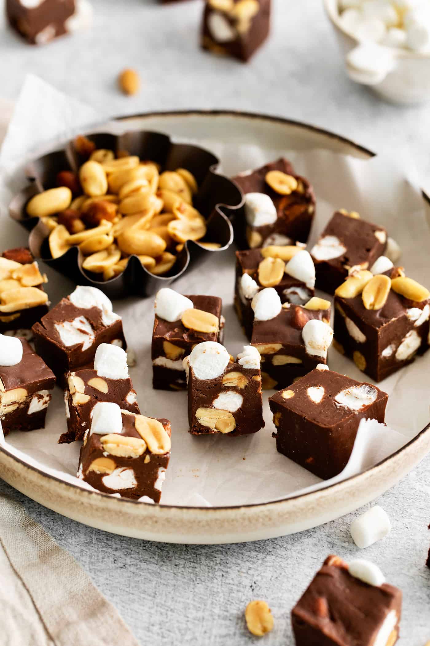 Quick and easy, this Rocky Road Fudge is made with creamy chocolate fudge stuffed with salty, crunchy peanuts and sweet, soft marshmallows. Overhead view of a plate of rocky road fudge