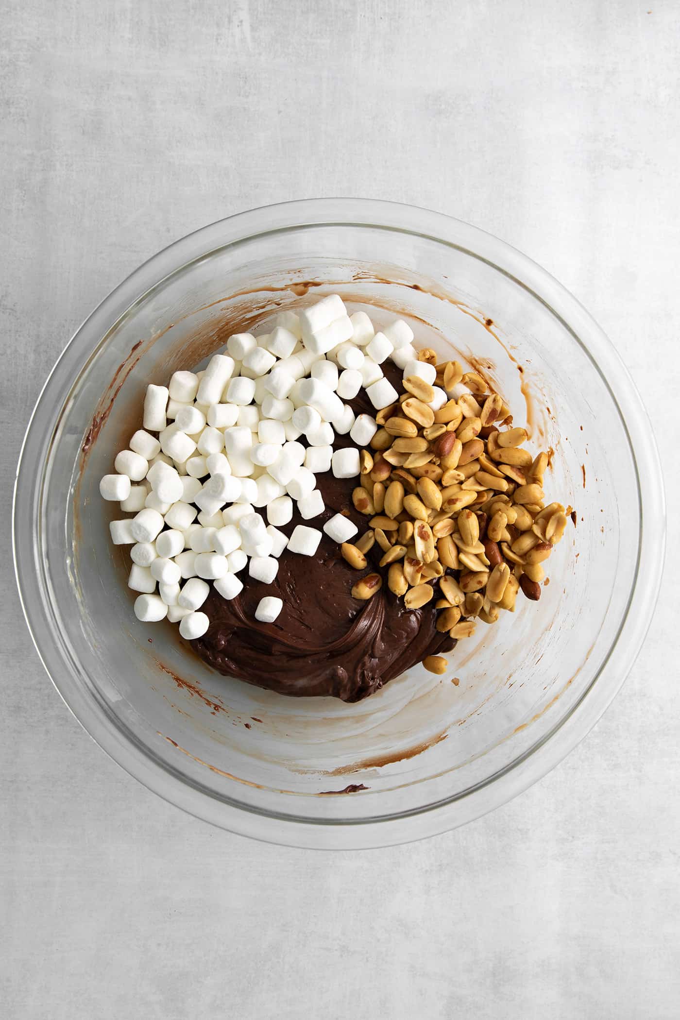 Quick and easy, this Rocky Road Fudge is made with creamy chocolate fudge stuffed with salty, crunchy peanuts and sweet, soft marshmallows. Marshmallows, peanuts, and melted chocolate in a bowl