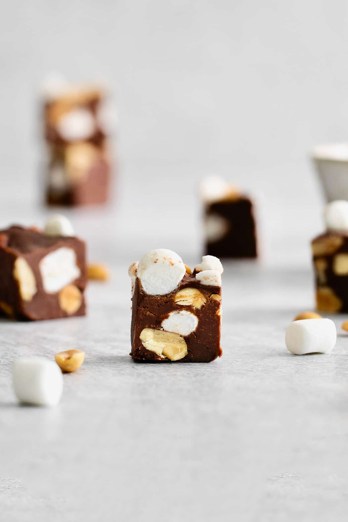 Quick and easy, this Rocky Road Fudge is made with creamy chocolate fudge stuffed with salty, crunchy peanuts and sweet, soft marshmallows. A piece of rocky road fudge on the counter