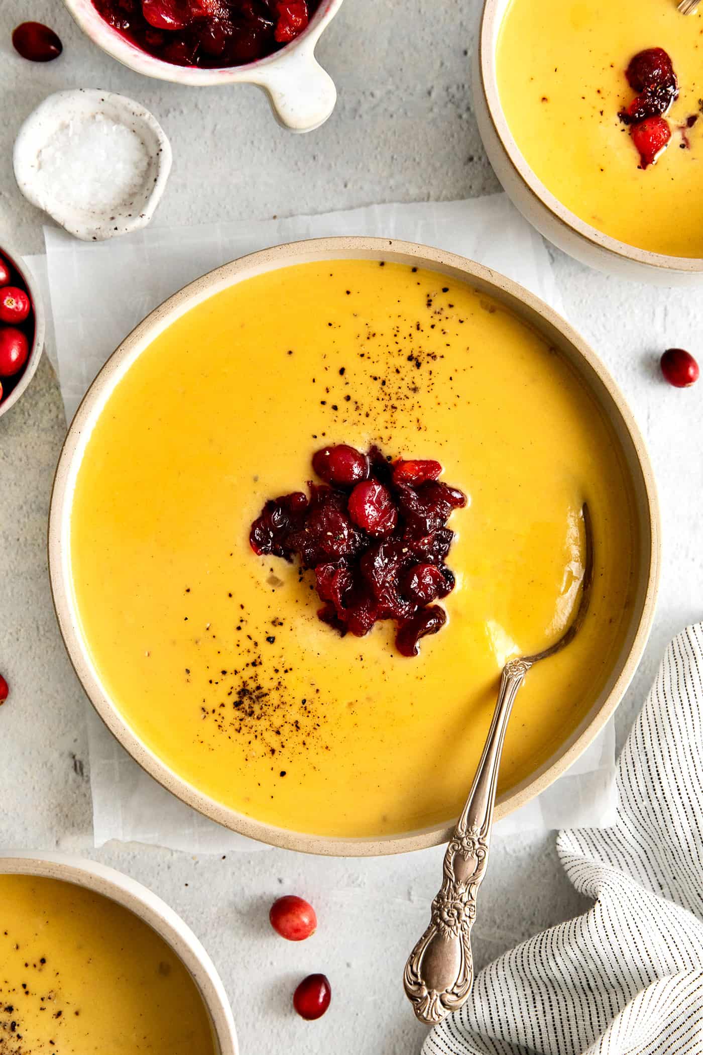 This Creamy Squash Soup with Cranberry Relish is made with squash, cream, warm spices and finished with a tart cranberry topping. Overhead view of roasted squash soup with cranberry relish