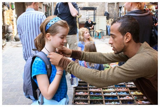 a man putting a necklace on a girl