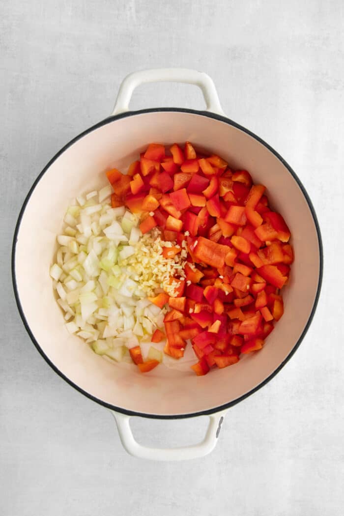 This easy chicken tortilla soup recipe is loaded with Mexican-style flavor, ready in 40 minutes! A perfect one pot soup recipe for weeknights! Diced bell peppers and diced onions in a soup pot