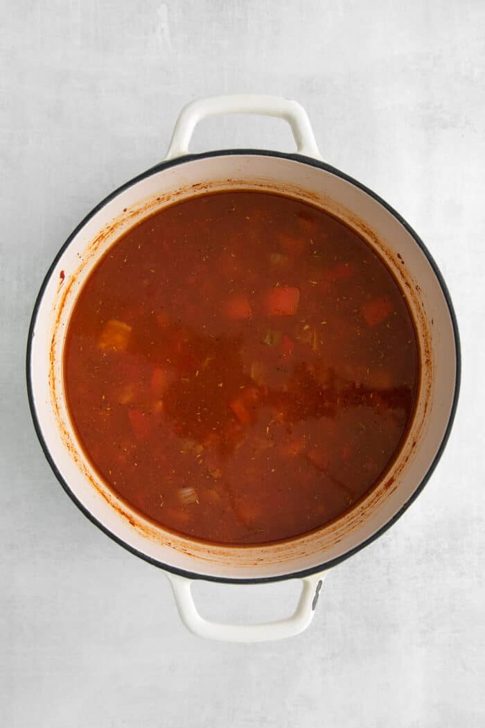 This easy chicken tortilla soup recipe is loaded with Mexican-style flavor, ready in 40 minutes! A perfect one pot soup recipe for weeknights! Chicken broth and tomato paste in a soup pot with vegetables