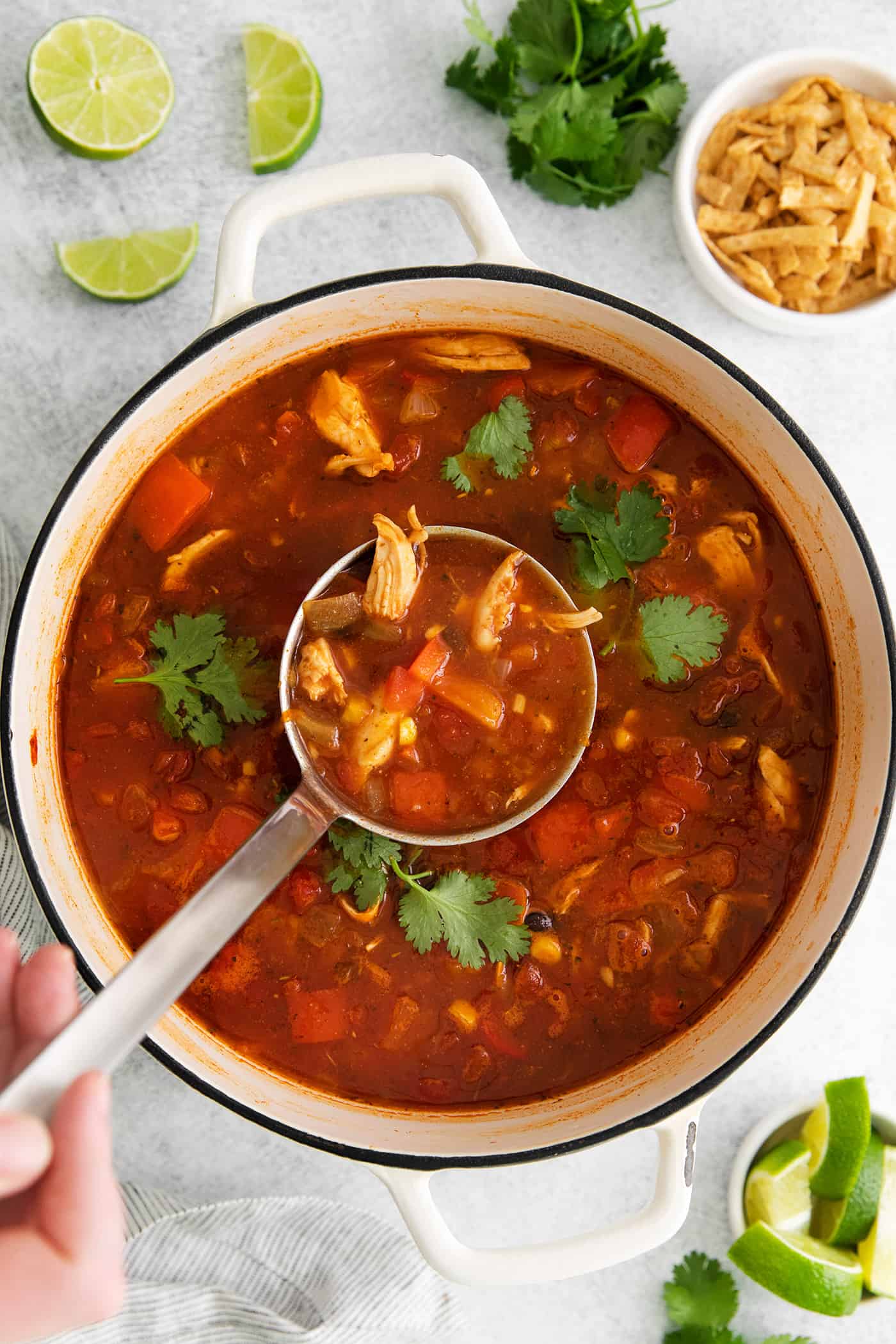 This easy chicken tortilla soup recipe is loaded with Mexican-style flavor, ready in 40 minutes! A perfect one pot soup recipe for weeknights! A ladle of tortilla soup over a soup pot