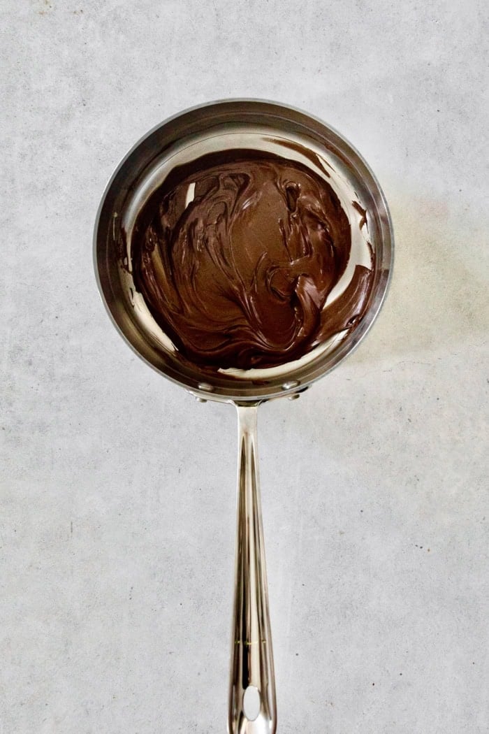 This recipe for homemade hot chocolate makes the creamiest and most decadent hot cocoa ever! It's easy to make and impossible to resist. Melted chocolate in pan