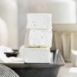 Stack of 3 homemade marshmallows on edge of sheet pan