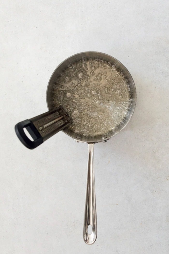 Homemade marshmallows are easier than you think! This recipe yields perfect fluffy marshmallows that are SO much better than store-bought. Syrup for marshmallows in pan with candy thermometer