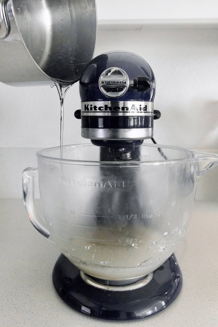 Homemade marshmallows are easier than you think! This recipe yields perfect fluffy marshmallows that are SO much better than store-bought. Pouring syrup into bowl of stand mixer