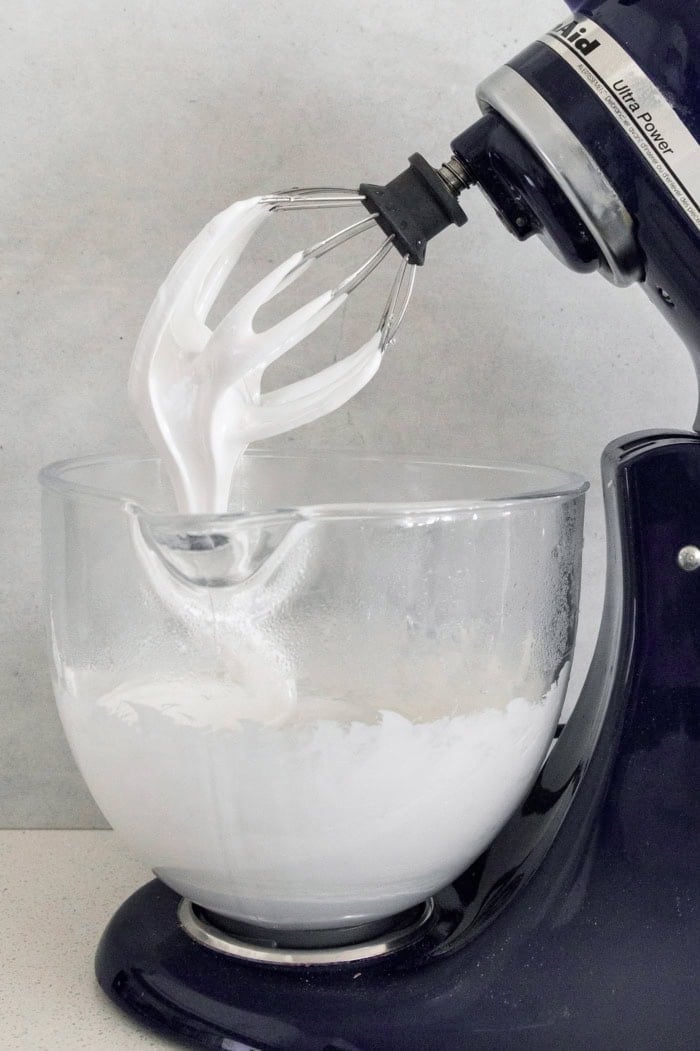 Homemade marshmallows are easier than you think! This recipe yields perfect fluffy marshmallows that are SO much better than store-bought. Marshmallow mixture in bowl of stand mixer fitted with whisk attachment