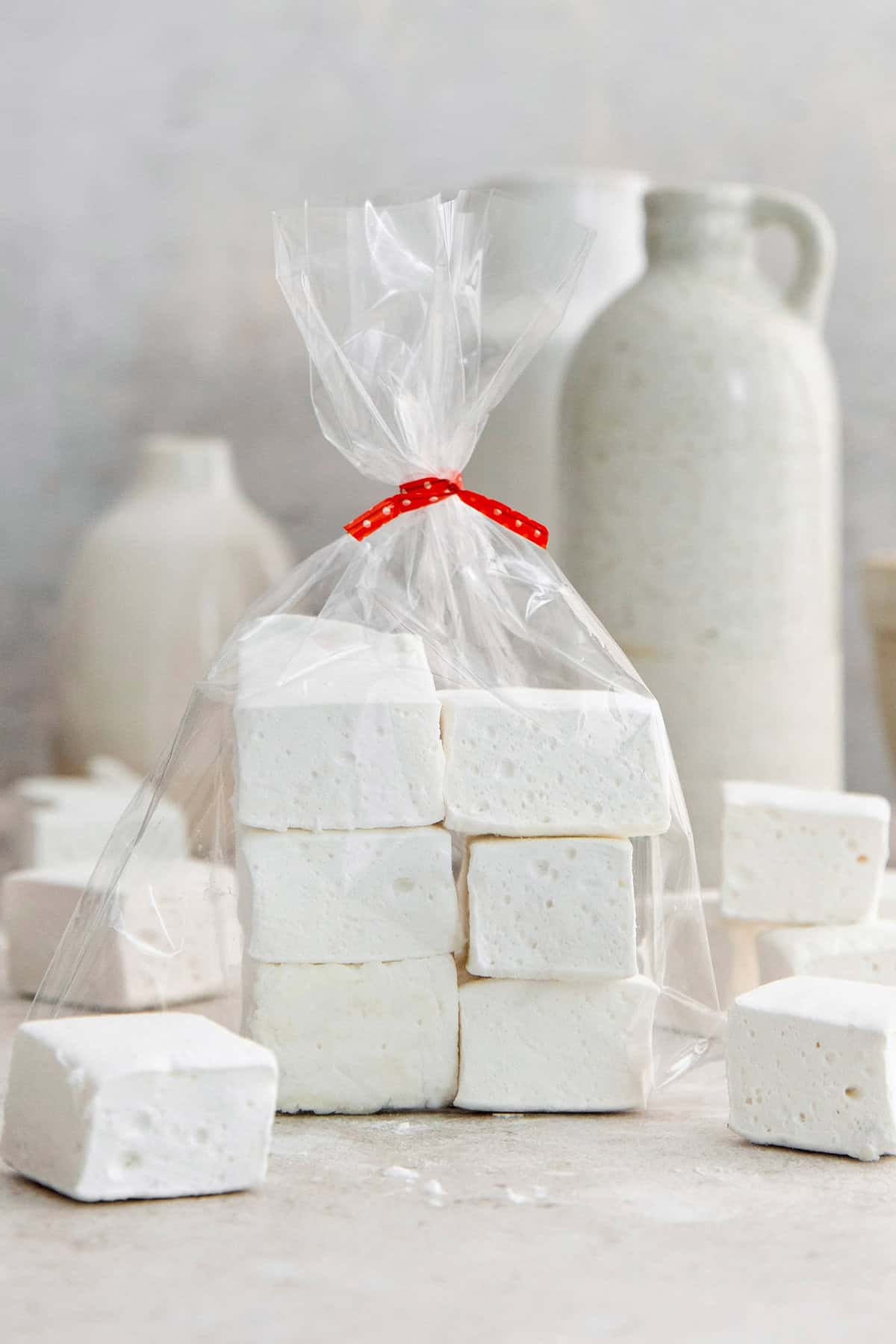 Homemade marshmallows are easier than you think! This recipe yields perfect fluffy marshmallows that are SO much better than store-bought. Homemade marshmallows in bag tied with red ribbon