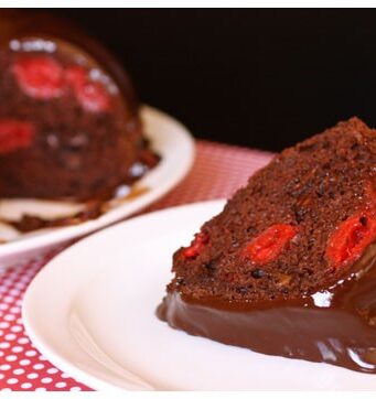 This slice of chocolate cherry cake is filled with cherries, chocolate, and topped with fudge.