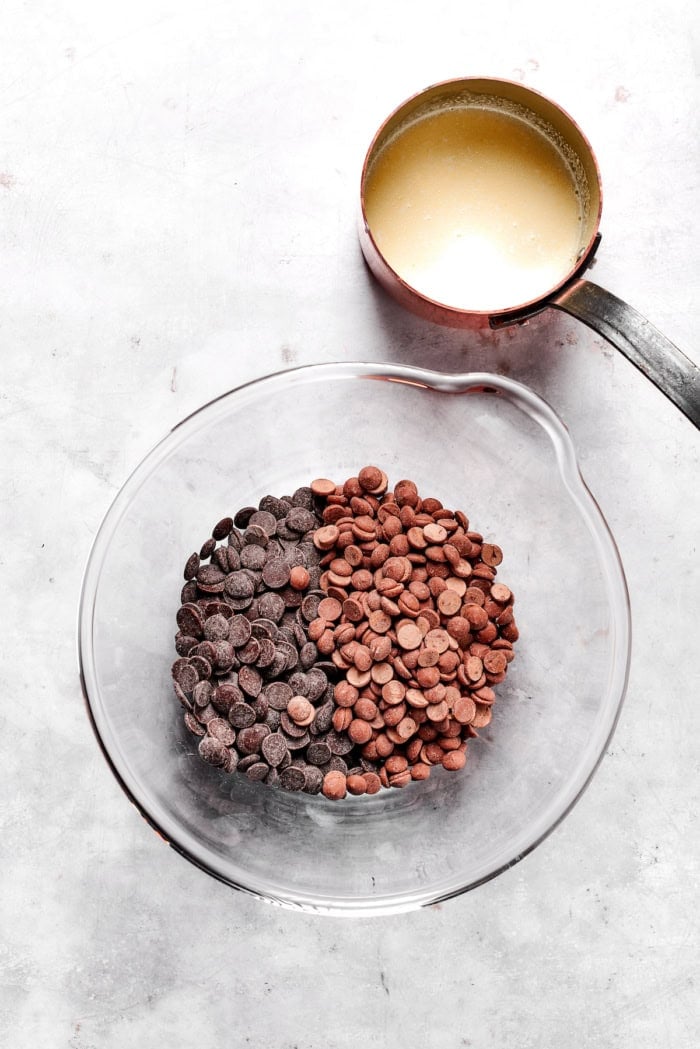 Melt-in-your-mouth Chocolate Truffles are an indulgence worth making from scratch. This easy recipe calls for only 6 simple ingredients! Chocolate chips in bowl with heavy cream in pan