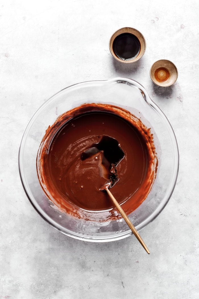 Melt-in-your-mouth Chocolate Truffles are an indulgence worth making from scratch. This easy recipe calls for only 6 simple ingredients! Spoon stirring vanilla and coffee into chocolate truffle mixture