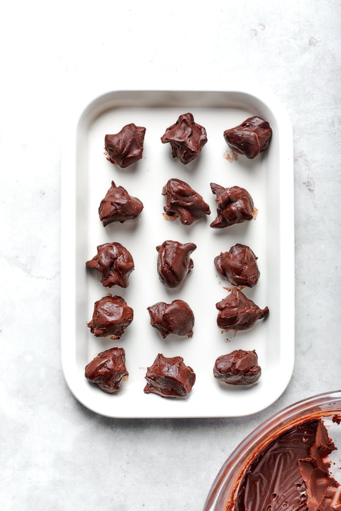 Melt-in-your-mouth Chocolate Truffles are an indulgence worth making from scratch. This easy recipe calls for only 6 simple ingredients! Overhead view of chocolate truffle mixture portioned on pan