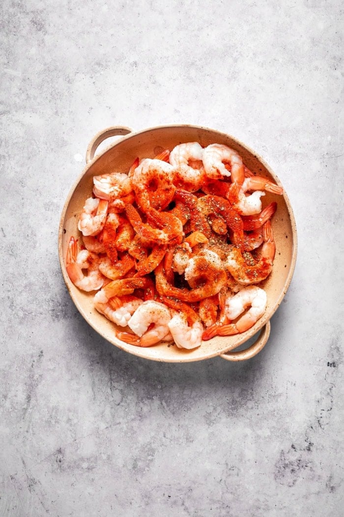 Rich without being heavy, garlicky with just a bit of heat, this Creamy Shrimp Pasta is a restaurant-worthy meal ideal for a date-night-in! Shrimp with seasonings in bowl.