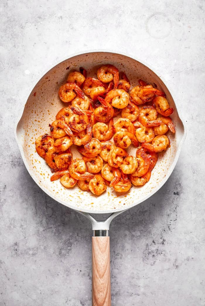 Rich without being heavy, garlicky with just a bit of heat, this Creamy Shrimp Pasta is a restaurant-worthy meal ideal for a date-night-in! Shrimp cooking in skillet.