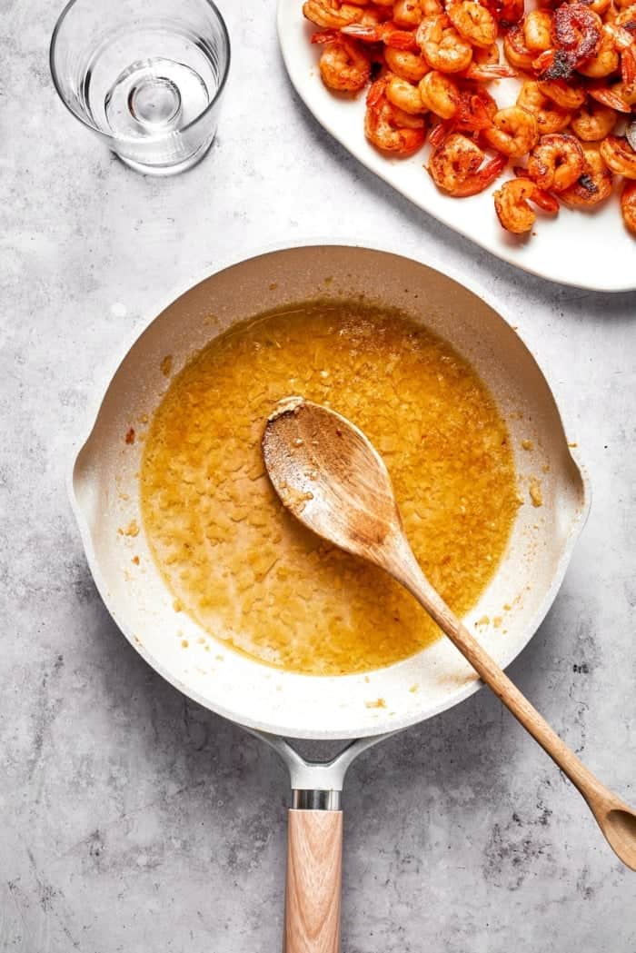 Rich without being heavy, garlicky with just a bit of heat, this Creamy Shrimp Pasta is a restaurant-worthy meal ideal for a date-night-in! Wine added to sauteed garlic and onion in skillet.