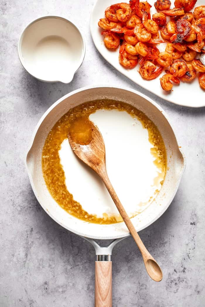 Rich without being heavy, garlicky with just a bit of heat, this Creamy Shrimp Pasta is a restaurant-worthy meal ideal for a date-night-in! Heavy cream added to skillet for pasta sauce.