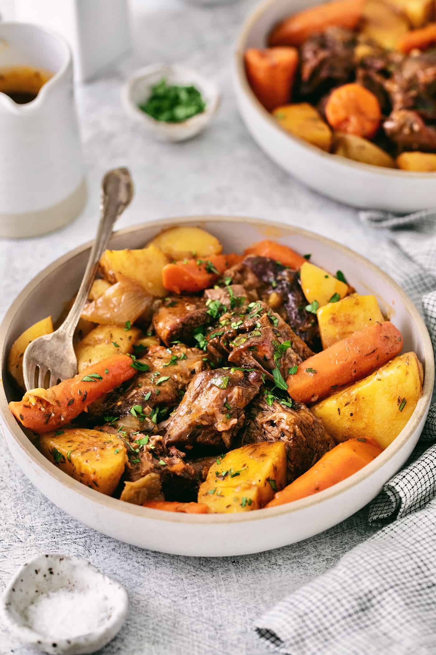 Made with chuck roast, potatoes, carrots, and onions in a beef broth, this Classic Pot Roast is comfort food at its finest. Hearty & filling! Beef pot roast with potatoes and carrots in a bowl