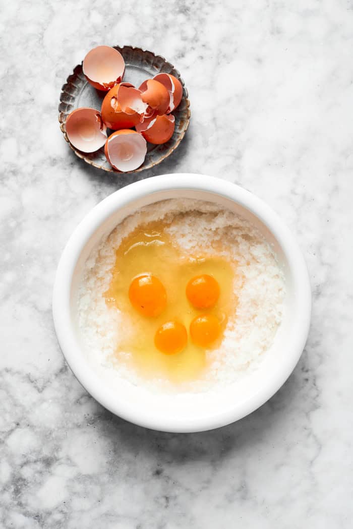 These fudgy brownies are a cinch to make with everyday pantry ingredients and the intensely fudgy texture and chocolate flavor is awesome! Overhead view of eggs added to sugar and oil in bowl