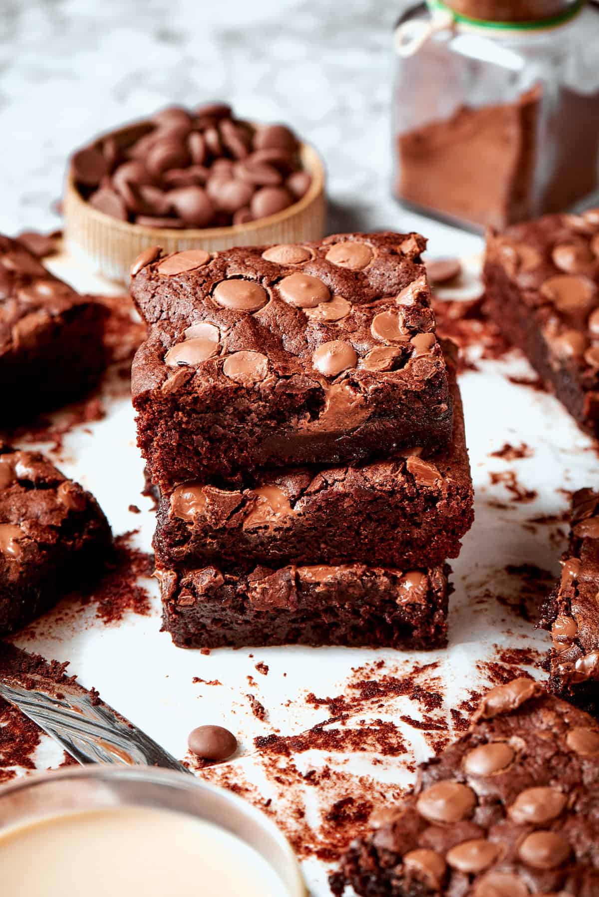 These fudgy brownies are a cinch to make with everyday pantry ingredients and the intensely fudgy texture and chocolate flavor is awesome! Stack of 3 fudgy brownies on parchment paper