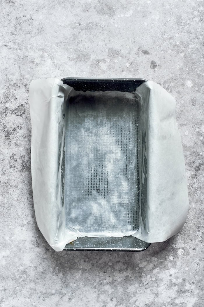 This moist orange poppy seed bread is soaked in a zippy citrus glaze for a bright, tender, bakery-style loaf perfect for brunch or gifting. Parchment paper inside loaf pan.