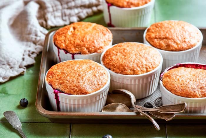 These mini blueberry cobblers are bursting with jammy berries and topped with a buttery, tender, flaky cobbler crust. An easy, rustic dessert! Mini blueberry cobblers on sheet pan.