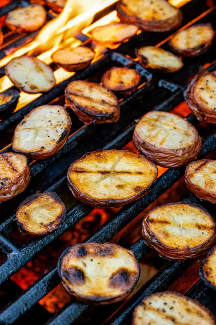 With smoky red potatoes and a rich blue cheese vinaigrette, this grilled potato salad recipe is so delicious, it might just steal the show! Red potato slices on grill grates